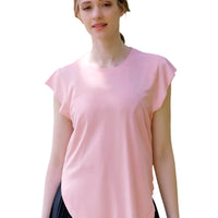 Woman wearing a pink top and black skirt standing in a park with cherry blossom trees.