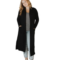 Woman wearing a black coat in a living room setting