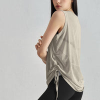 Woman wearing a beige sleeveless top with a drawstring detail on a gray background, featuring the brand 'CREORA'.
