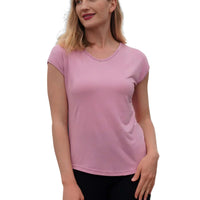 Woman wearing a pink t-shirt and black shorts against a dark background