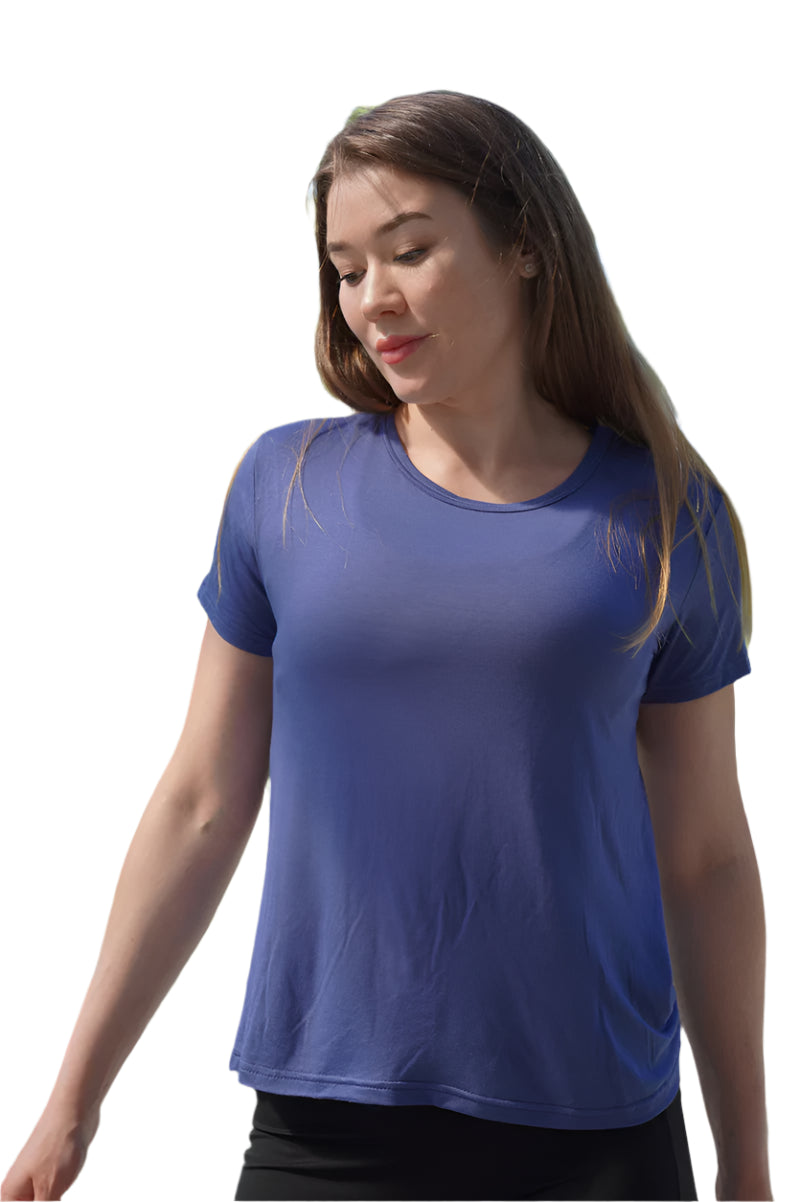 Woman wearing a blue t-shirt outdoors with greenery in the background