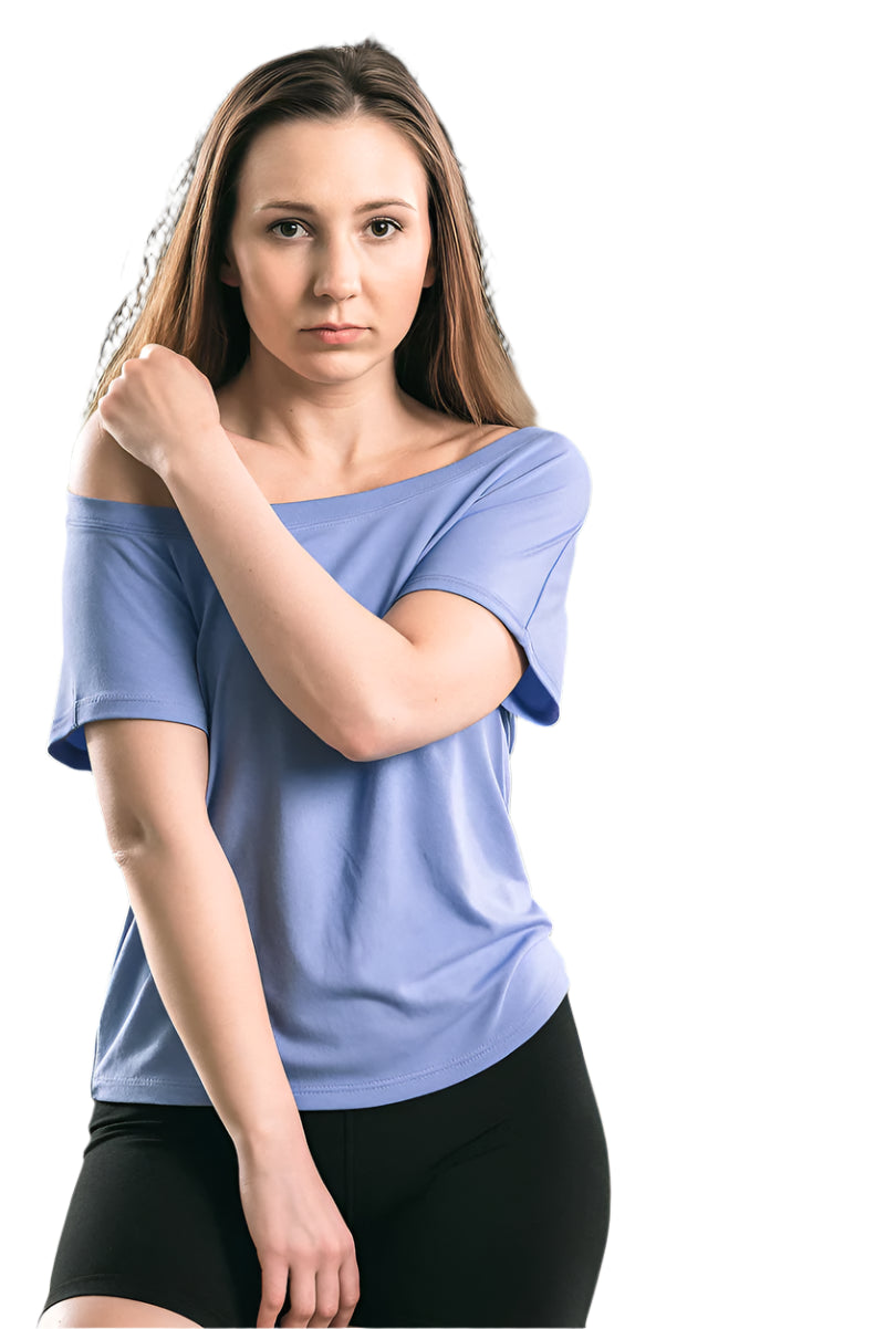 Woman wearing a blue off-shoulder top and black shorts outdoors.