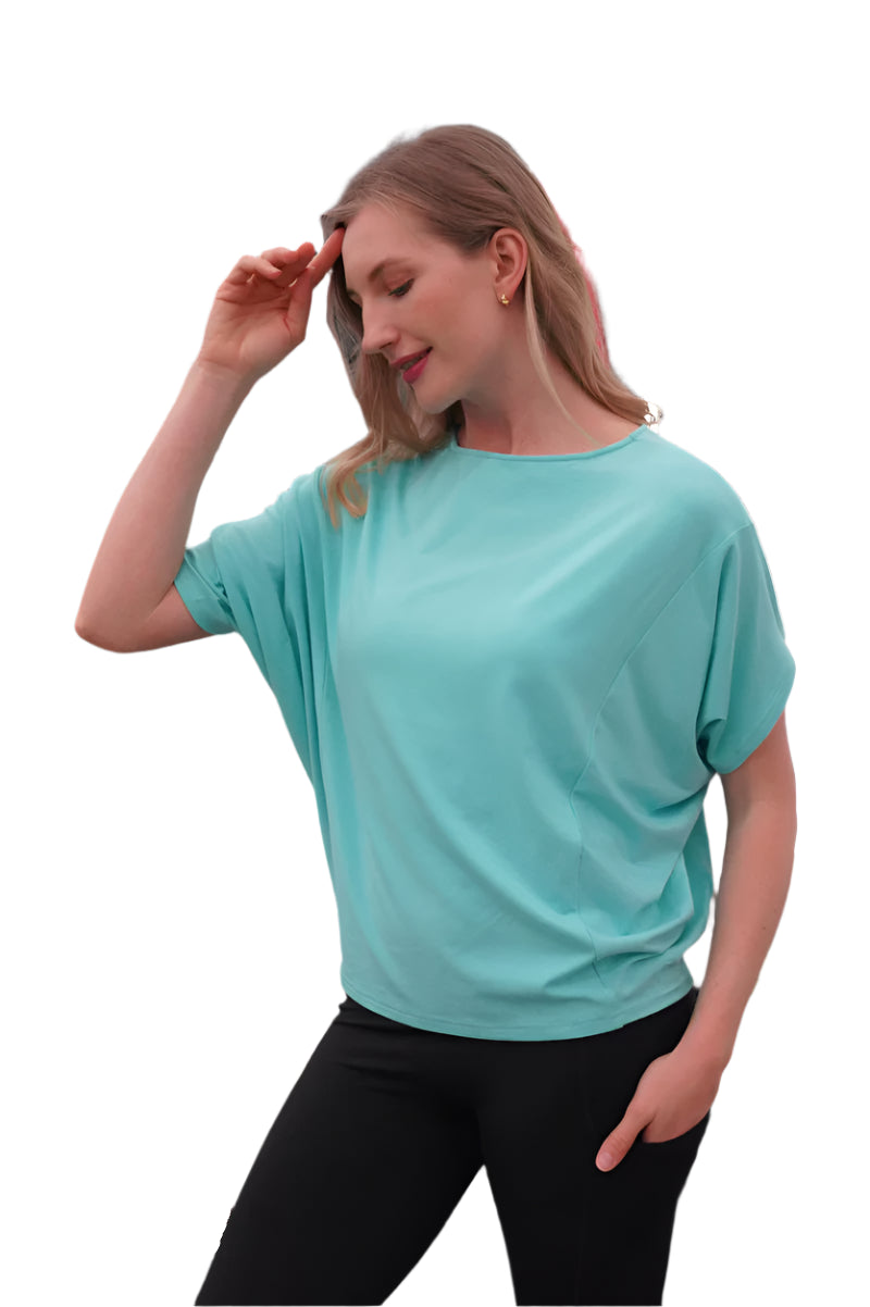 Woman wearing a teal t-shirt and black leggings in a gym setting