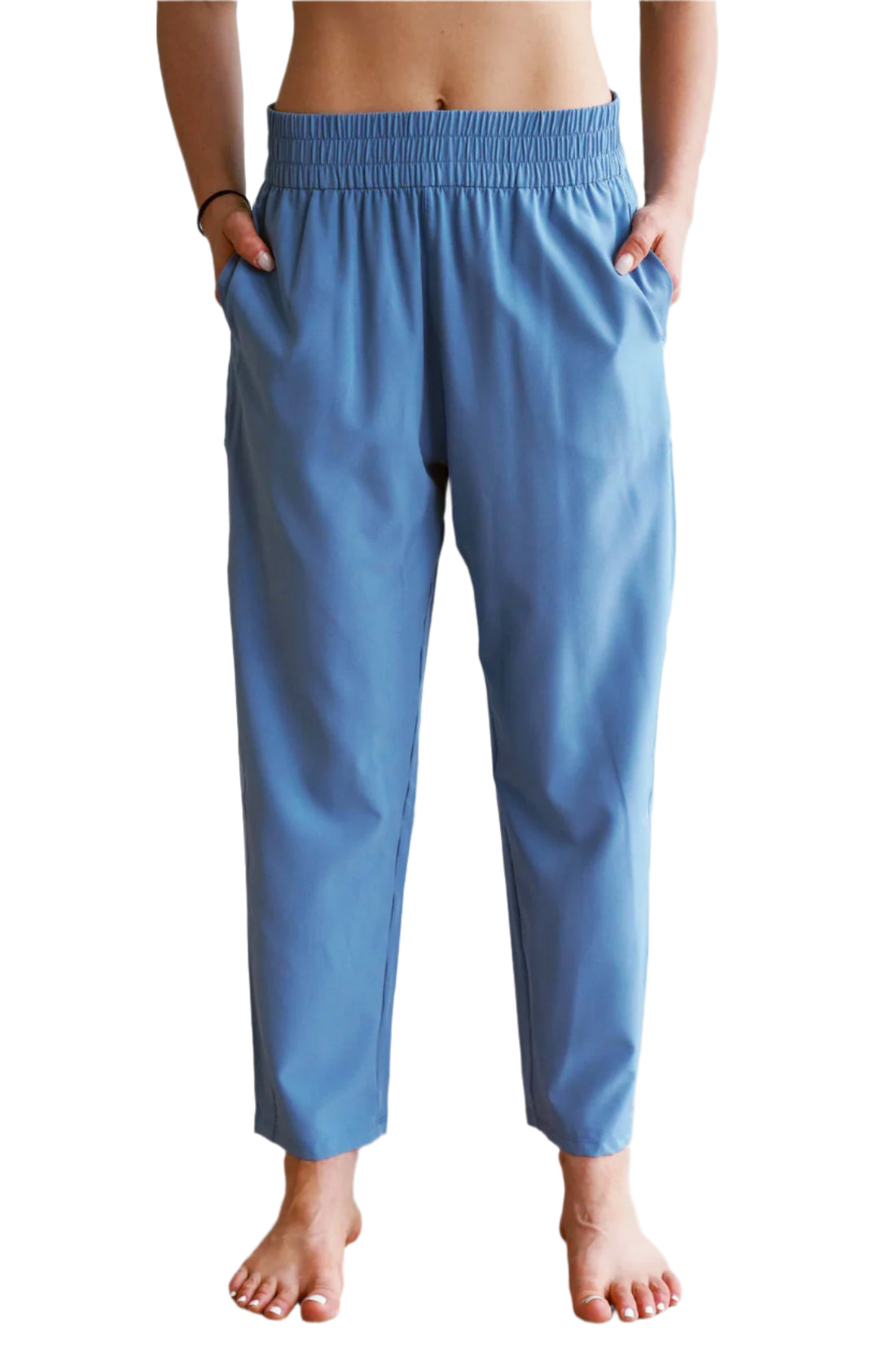 Person wearing blue pants standing indoors with a blurred background