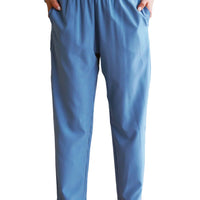 Person wearing blue pants standing indoors with a blurred background