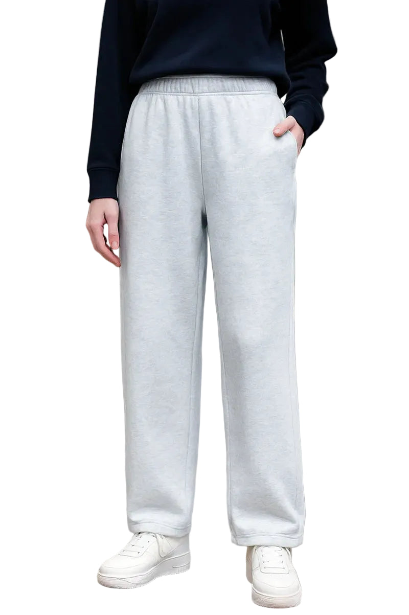 Person wearing light gray sweatpants and white sneakers on a city street.