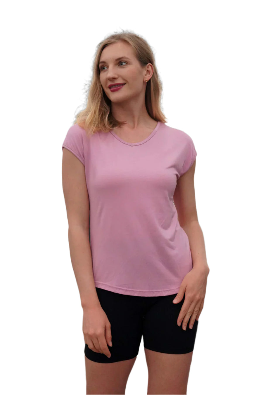 Woman wearing a pink t-shirt and black shorts against a dark background